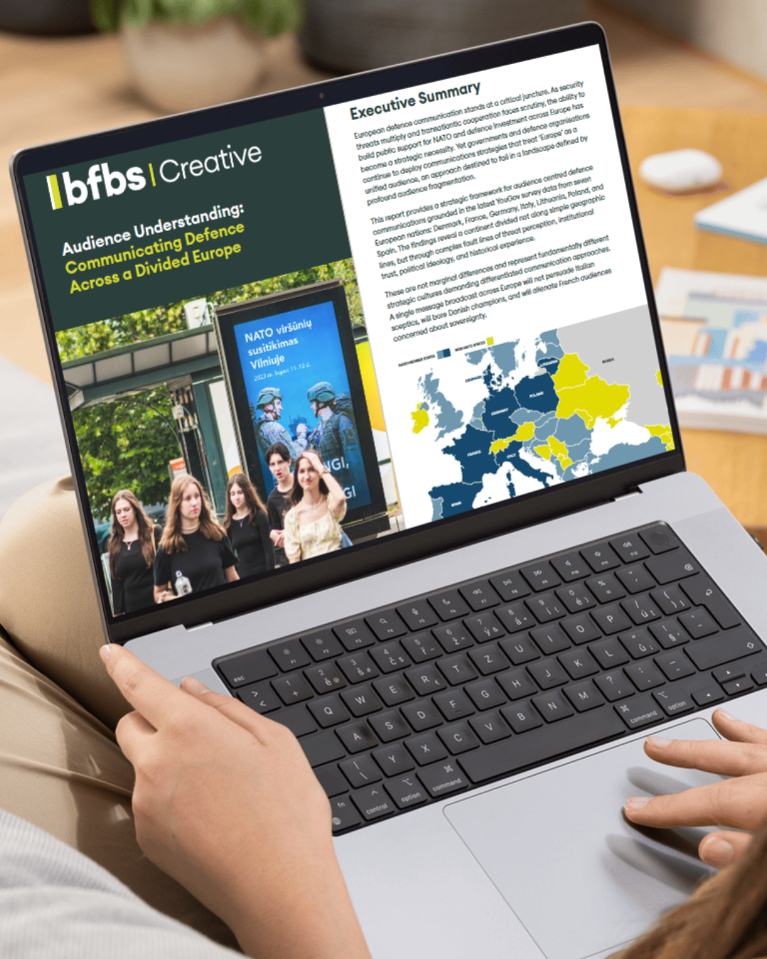 Report shown on a laptop full screen, resting on someone's lap.