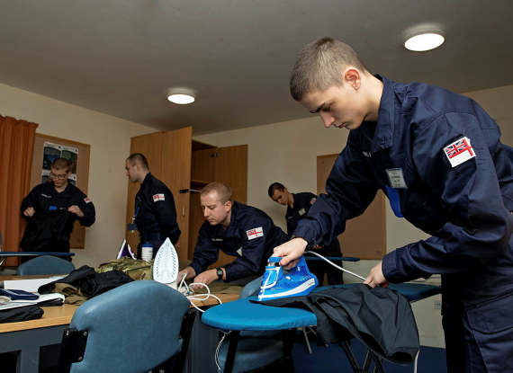 Defence imagery photo of recruits preparing their uniform. 