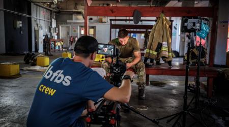 team member filming someone in uniform