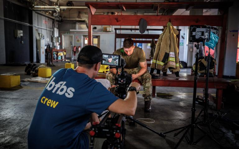team member filming someone in uniform