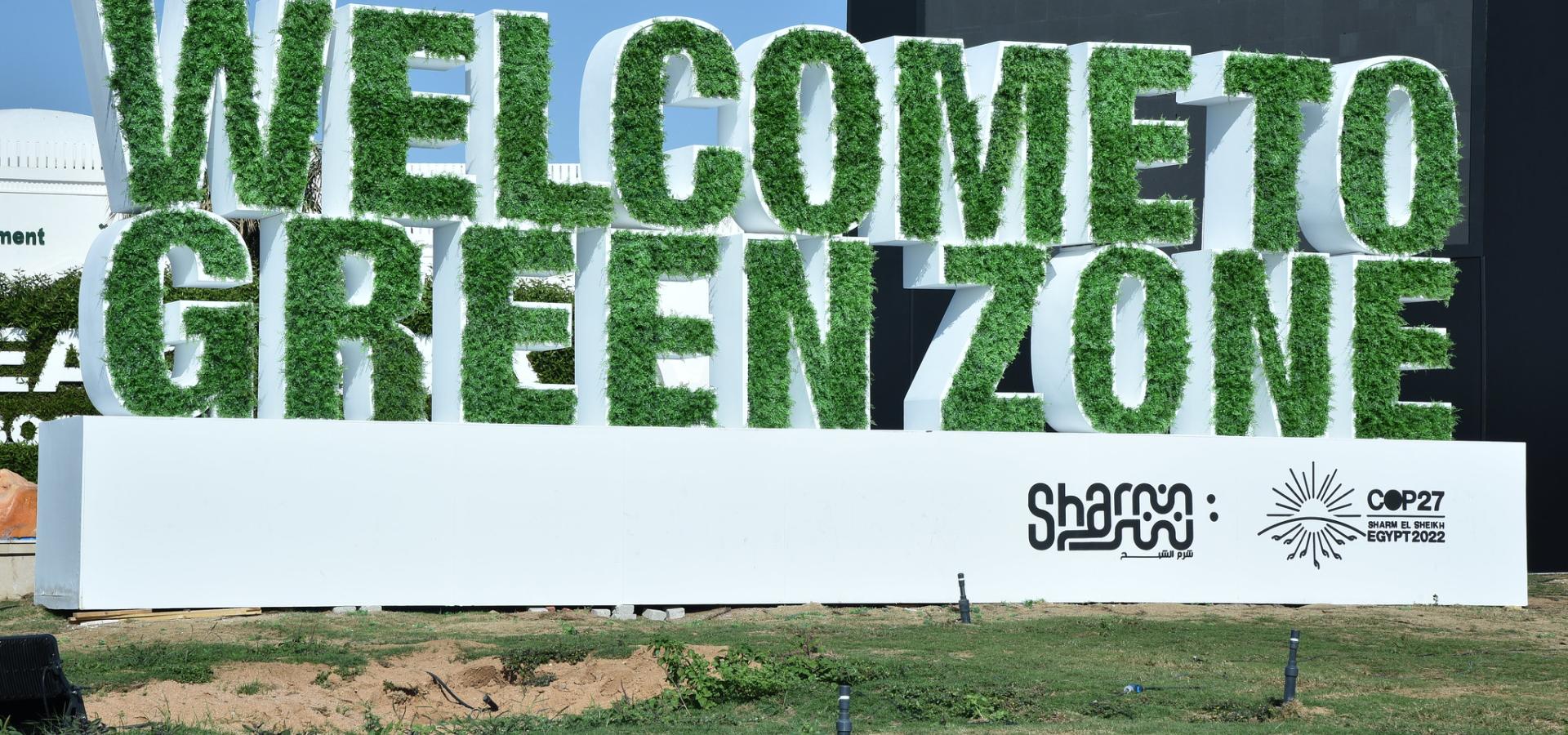 A sign made of grass reads  'Welcome to Green Zone'