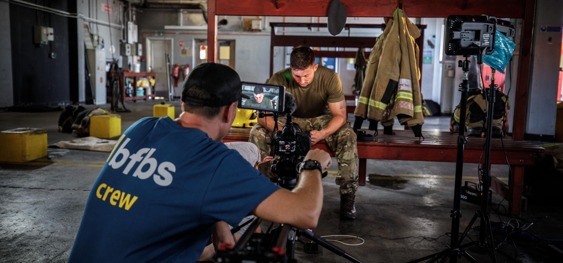 team member filming someone in uniform